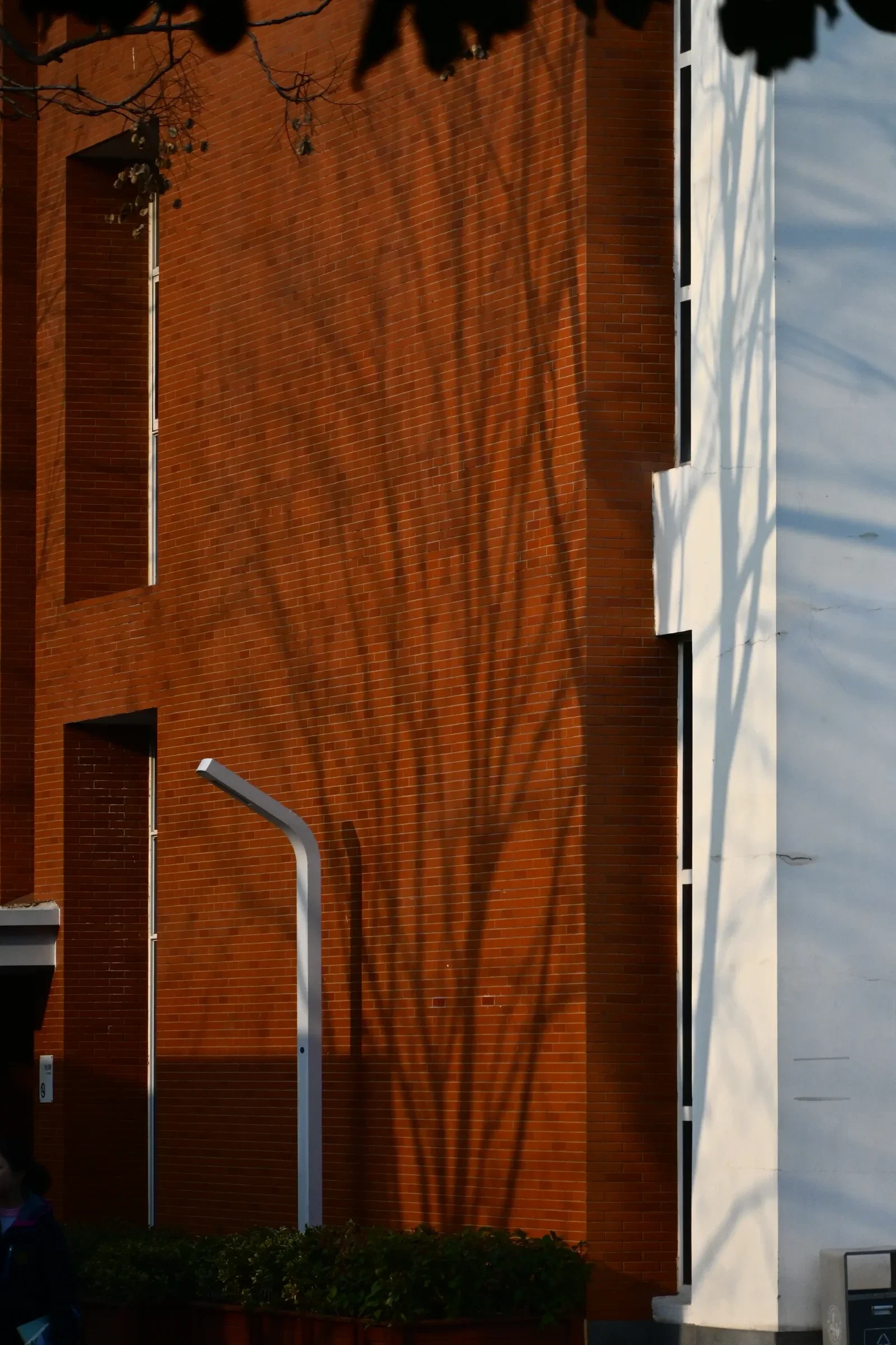 Warm sunlight falls across a red building facade and a narrow doorway.